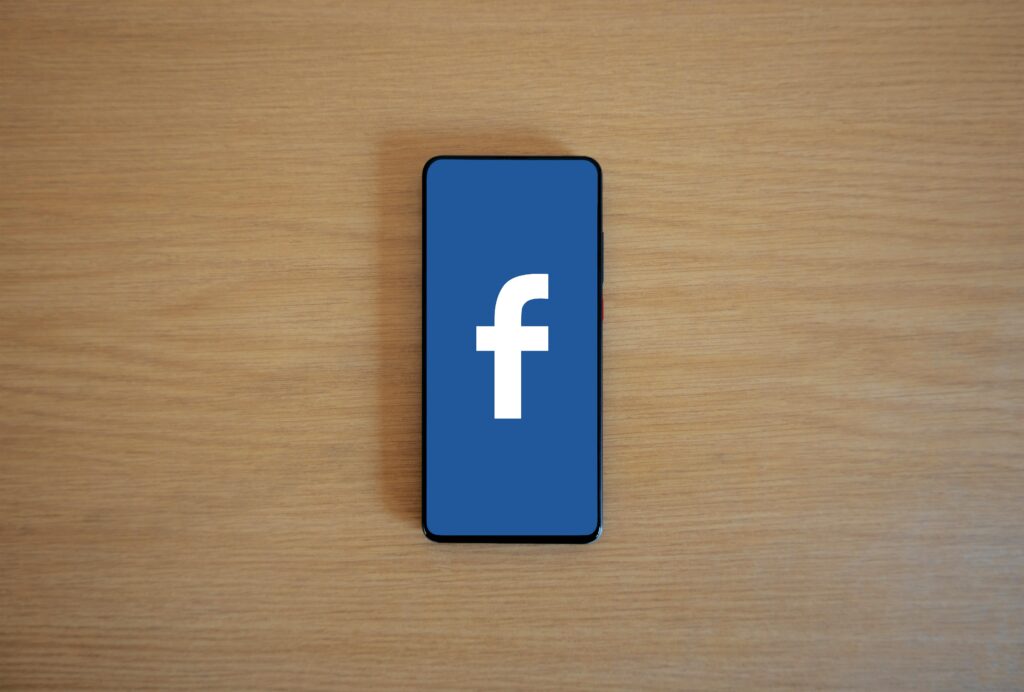 pexels photo 20716651 20716651 Smartphone with Facebook logo on screen, placed on a wooden background. Top view.