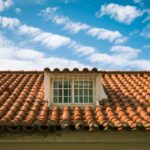 Close-up of a terracotta tiled roof with a skylight window in sunny Marbella, Spain.
